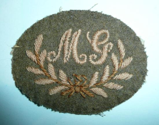 MG in Wreath Embroidered Khaki Cloth British Army Proficiency Arm Badge - 1st Class Machine Gunner / Machine Gun Marksman